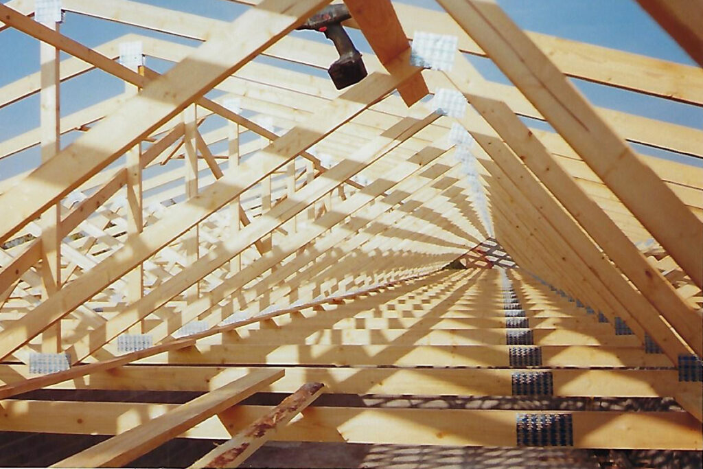 estructura para cubierta, con caballos y bigas de madera laminada de abeto en obra para terminar. encima, panel de la casa Thermochip.
